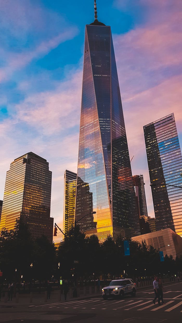 One World Trade Center reflecting sunset hues in New York City skyline.